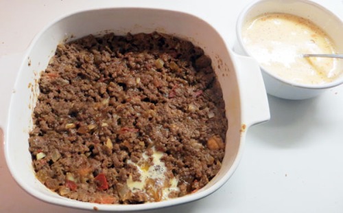 Pack ground beef in dish for bobotie